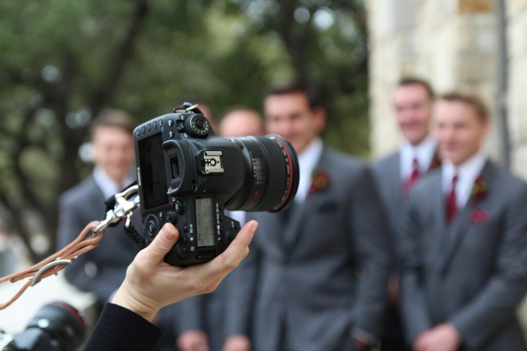 Fotograf im Anzug mit Spiegelreflexkamera bei einer Hochzeit