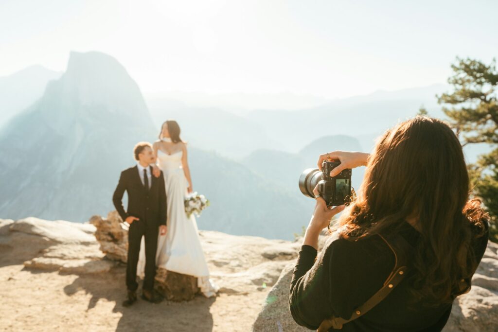 Hochzeitsfotos Trends: Brautpaar posiert für den Fotografen an einem Aussichtspunkt in den Bergen