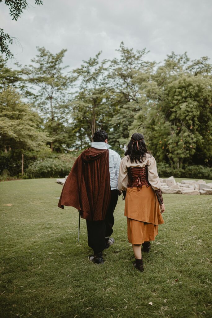 Mottohochzeit im Renaissance-Stil: Paar in historischer Kleidung spaziert durch einen Park