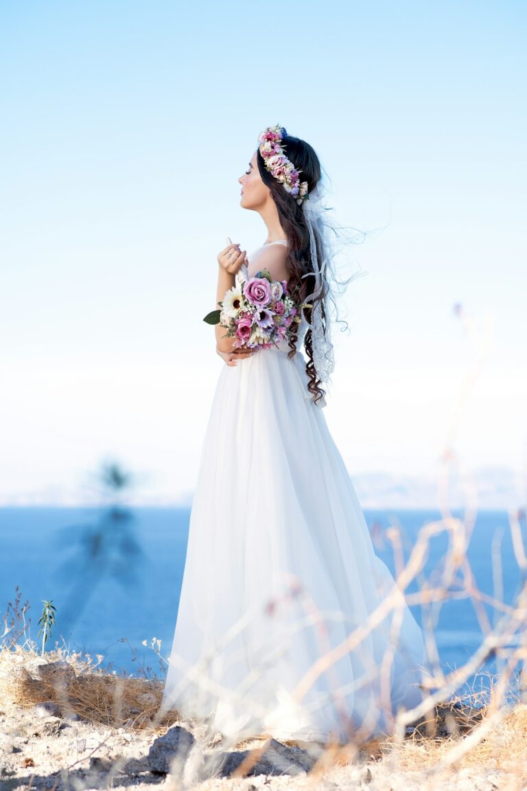 Braut auf einer sommerlichen Wiese im Boho Hochzeitskleid mit Spitze