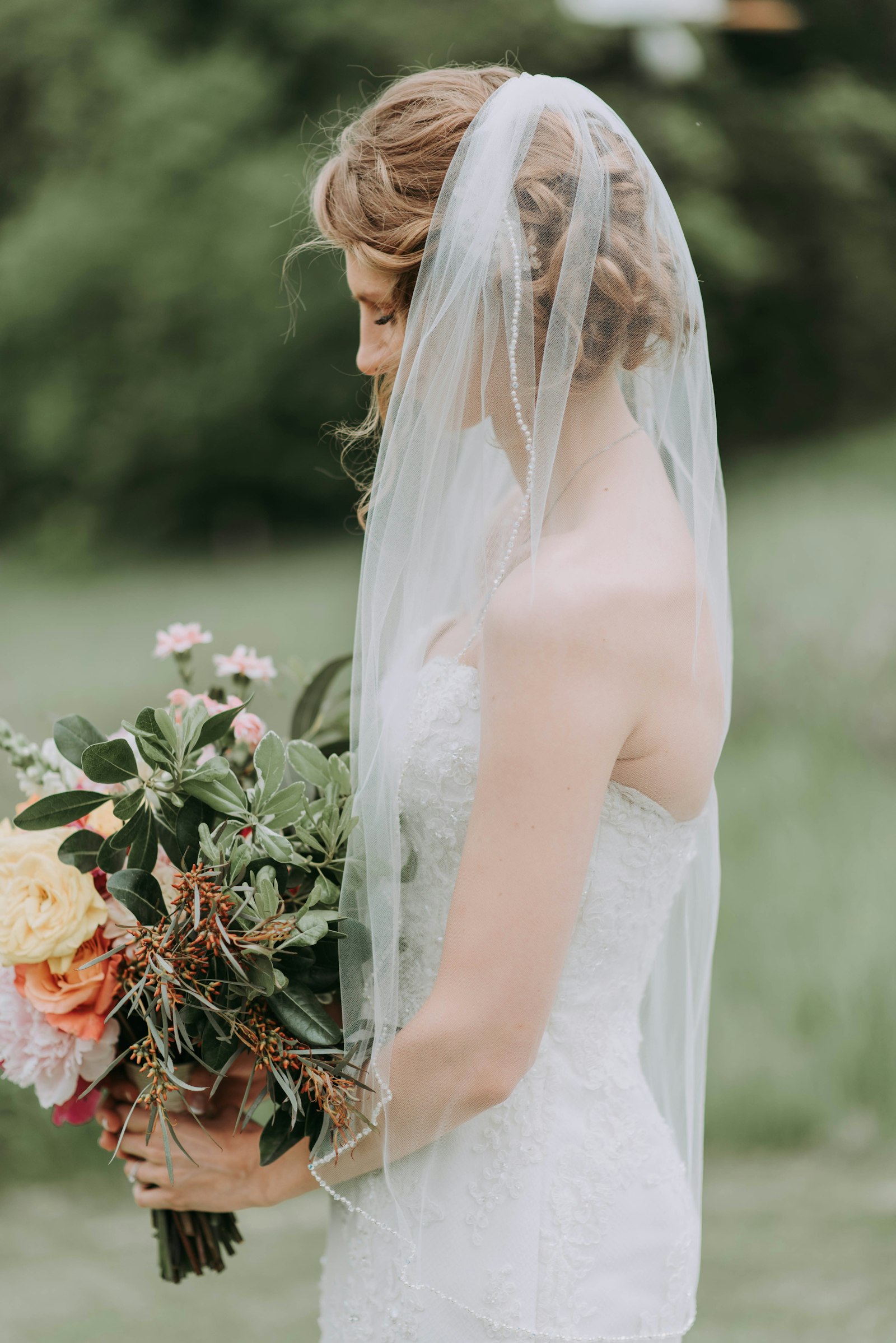 Braut in weißem Hochzeitskleid mit Brautschleier