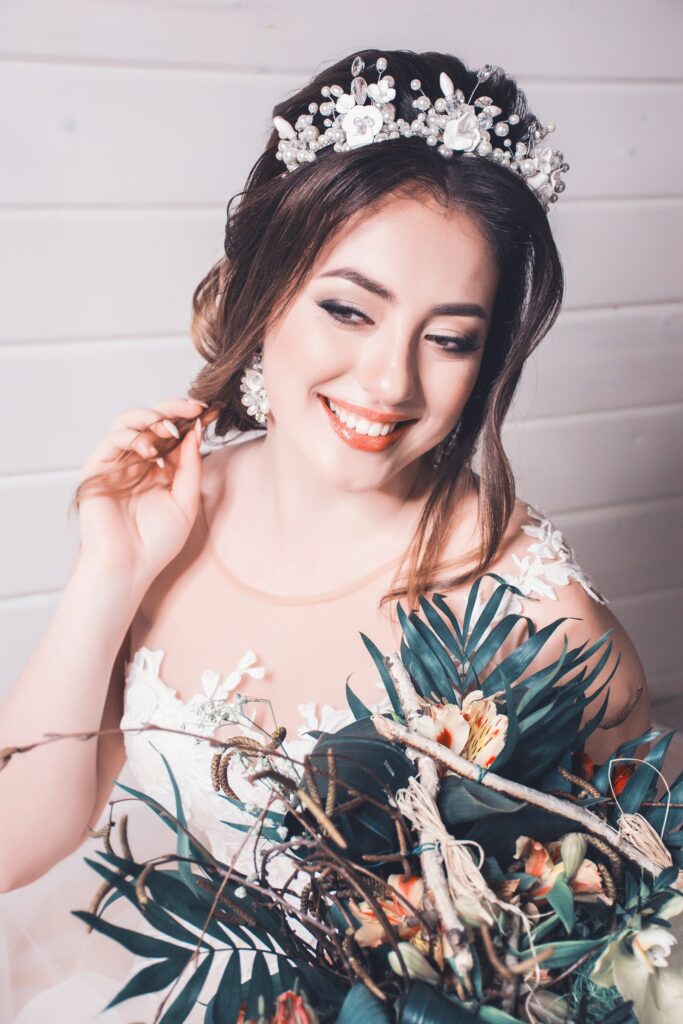 Braut mit Tiara im Haar hält einen Blumenstrauß