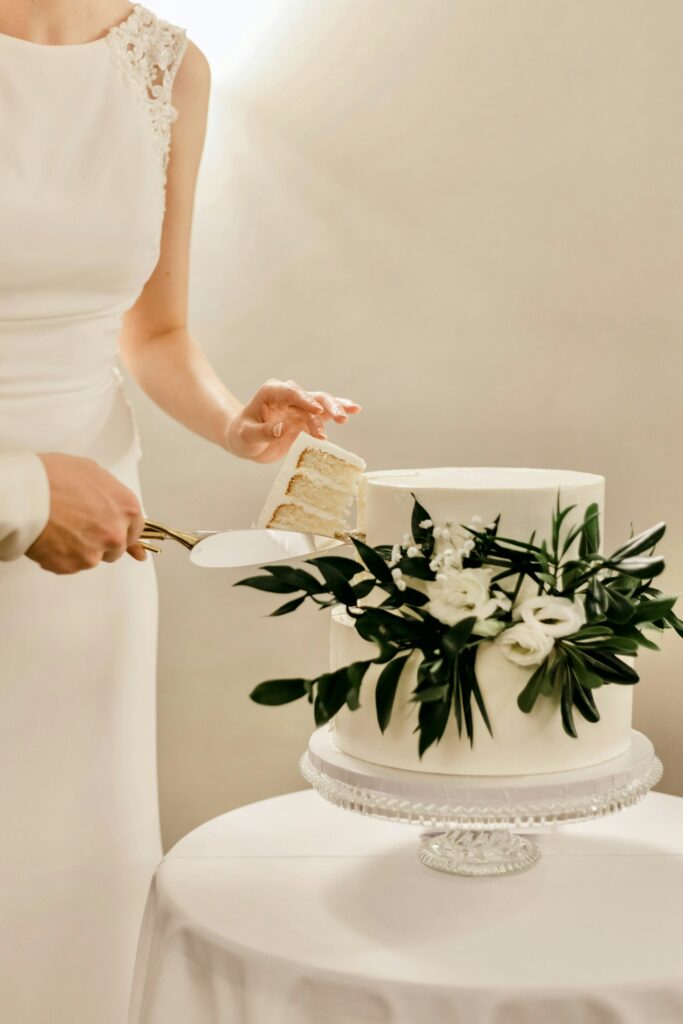 Braut schneidet die Hochzeitstorte beim Empfang an
