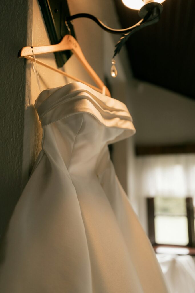Brautkleid schlicht: trägerloses weißes Kleid auf einem Holzbügel