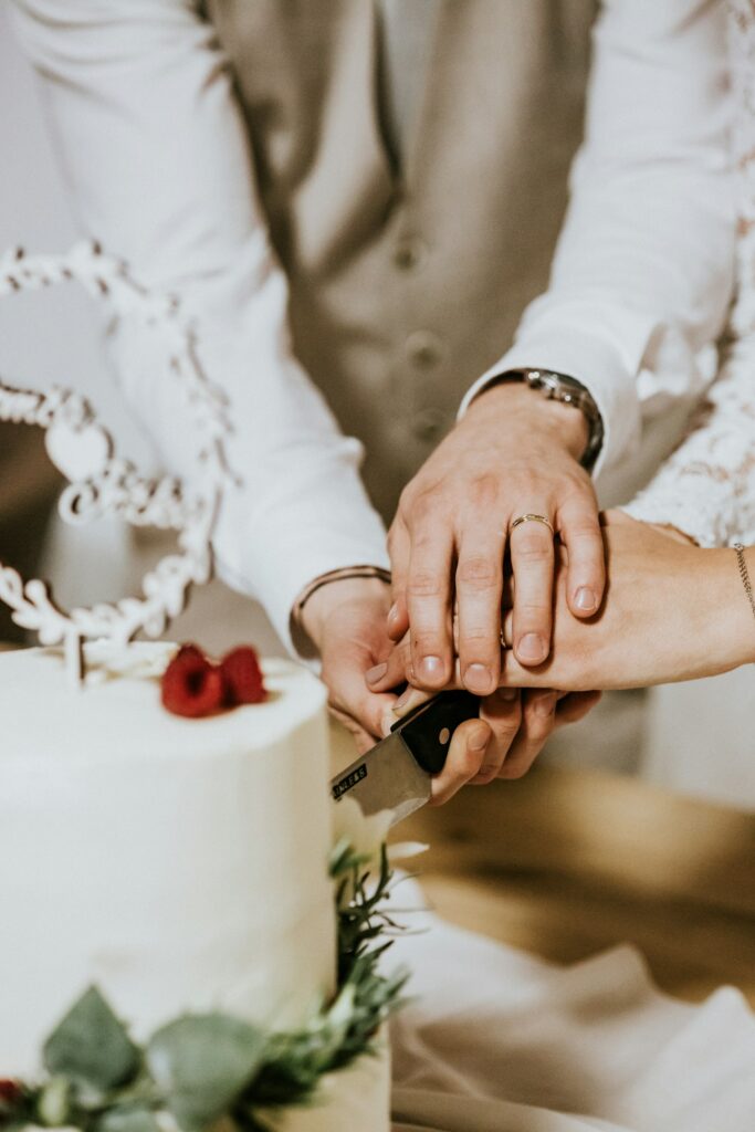 Brautpaar schneidet gemeinsam die Hochzeitstorte an