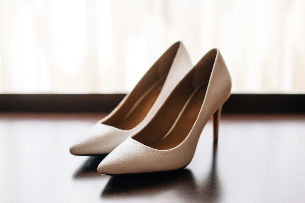 Brautschuhe Trends: weiße Pumps mit strukturierter Oberfläche auf dunklem Untergrund