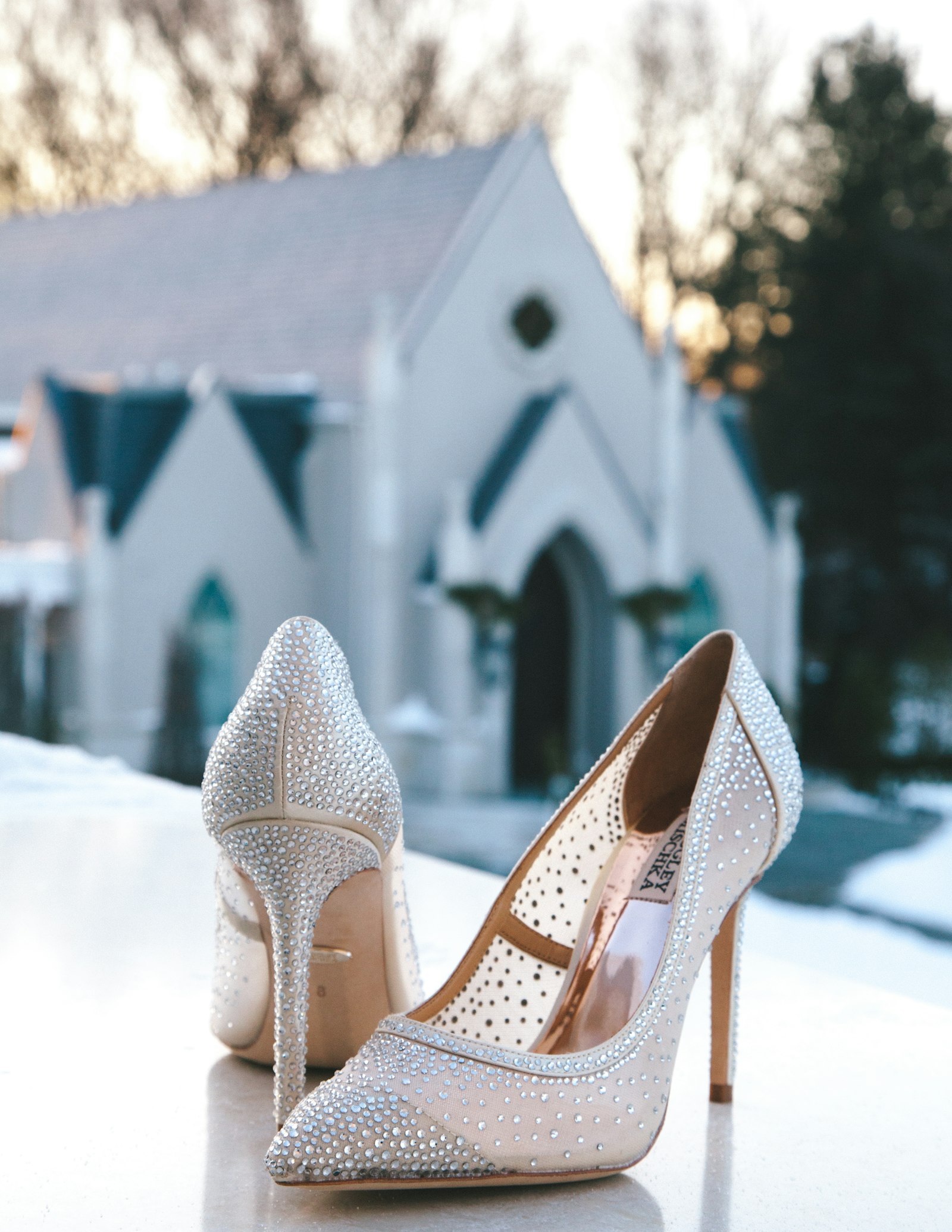 Glitzernde Brautschuhe vor einer Kapelle