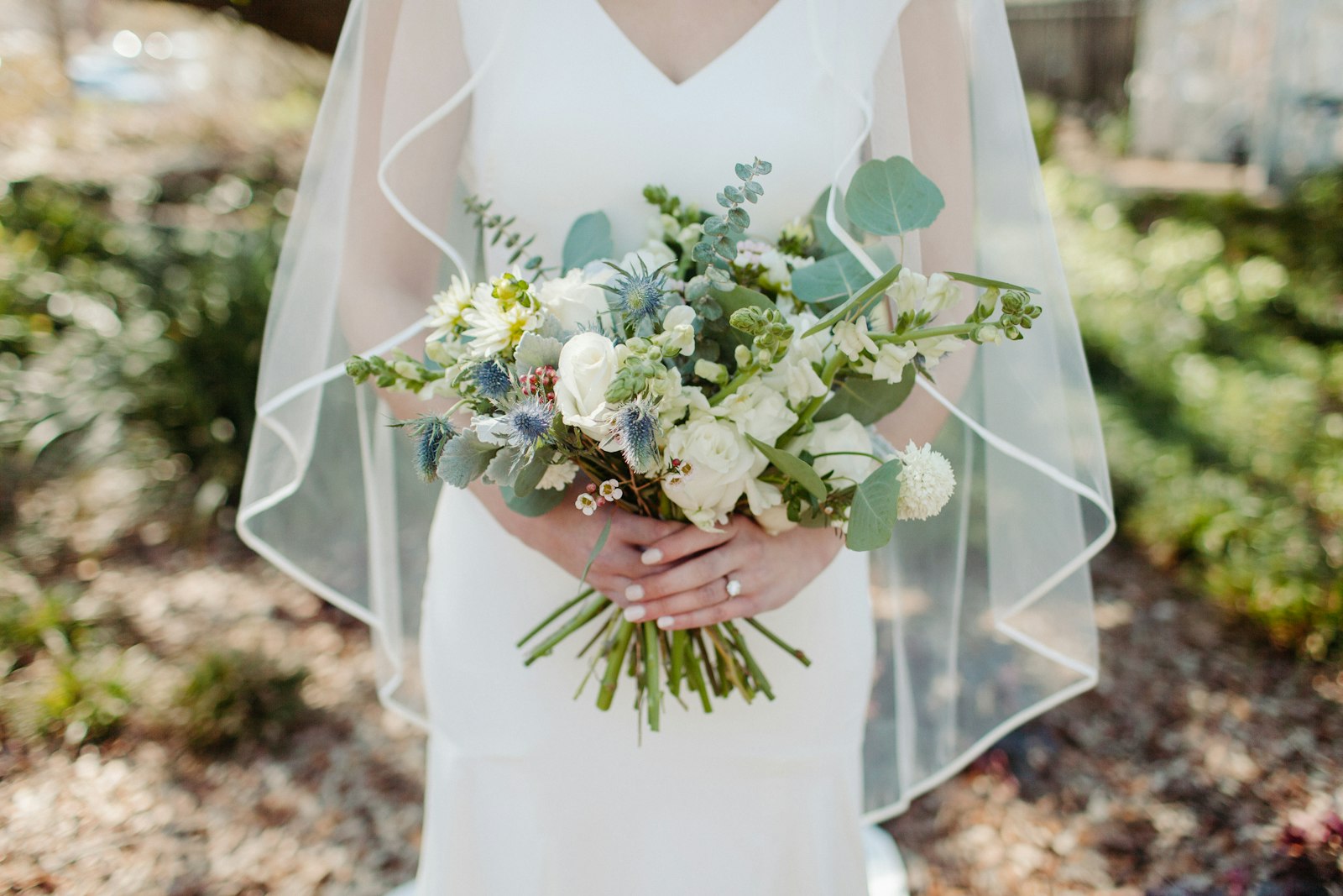 Brautstrauß Standesamt: Braut im weißen Kleid hält einen weißen Blumenstrauß