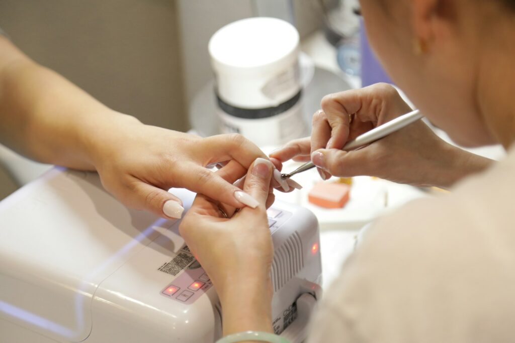 Frau lässt sich im Nagelstudio die Nägel machen