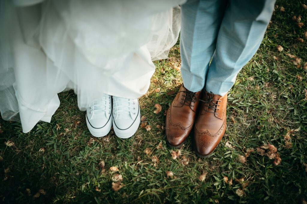 Füße von Braut und Bräutigam auf einer Wiese bei der Gartenhochzeit