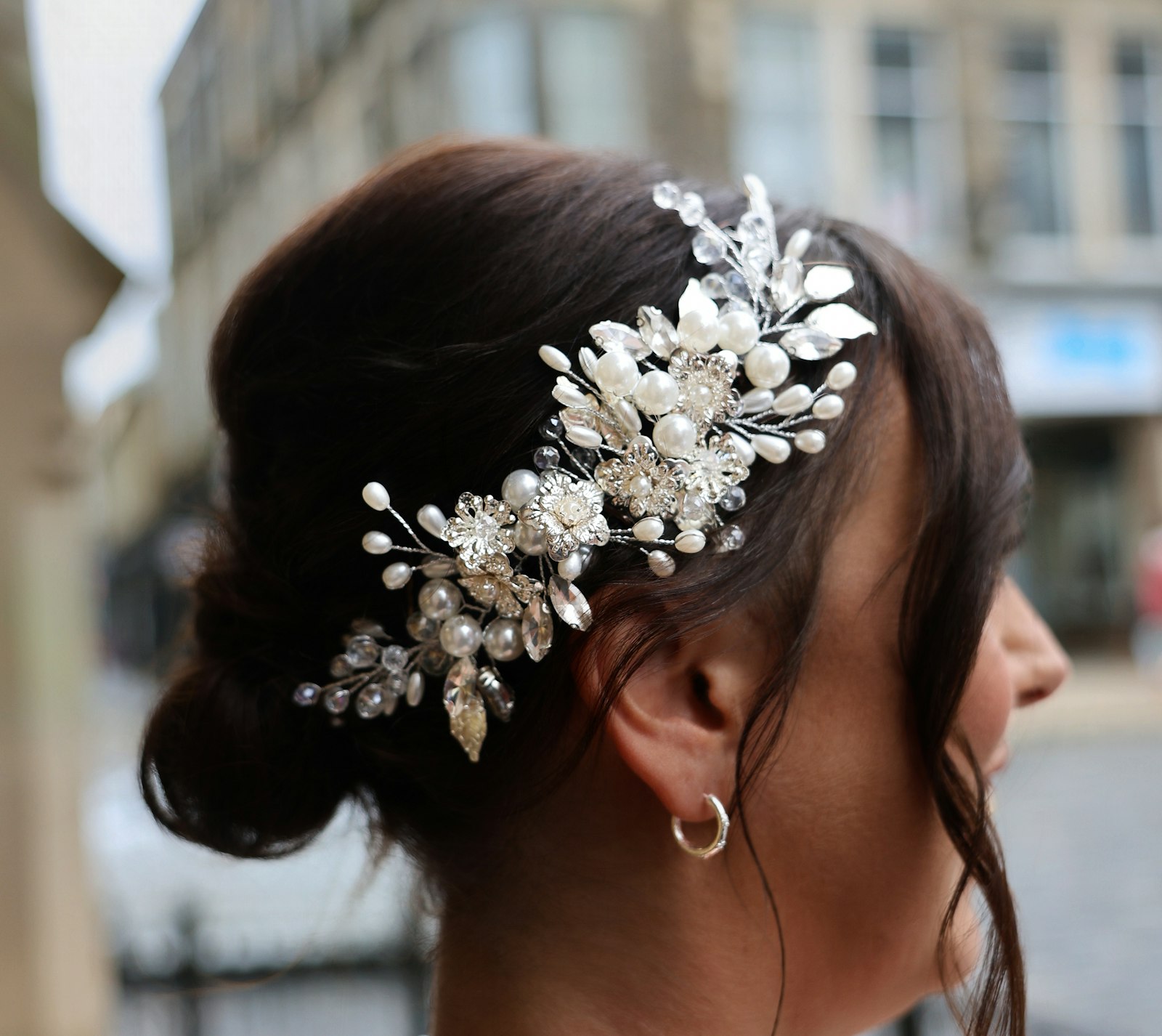 Haarschmuck Braut: Frau trägt ein Haaraccessoire aus Perlen und Kristallen