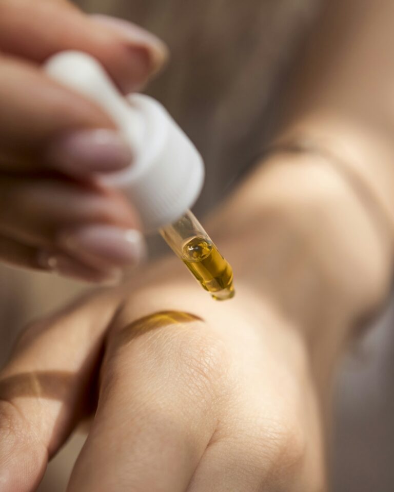 Pipette mit Gesichtsöl über der Haut