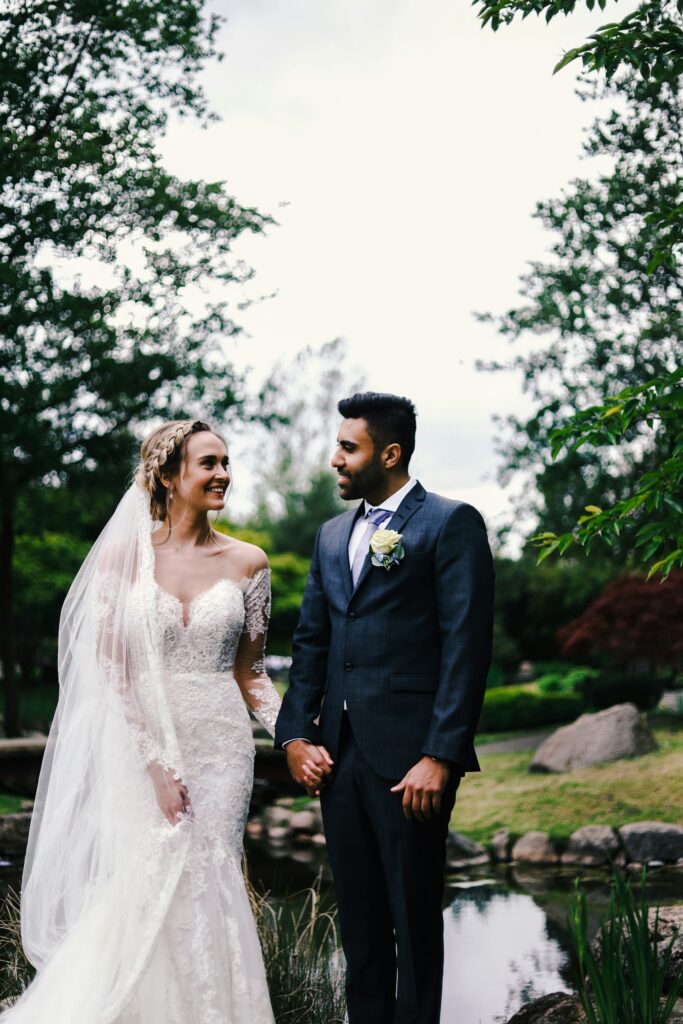 Heiraten Dänemark: Brautpaar hält sich an den Händen vor einem Teich