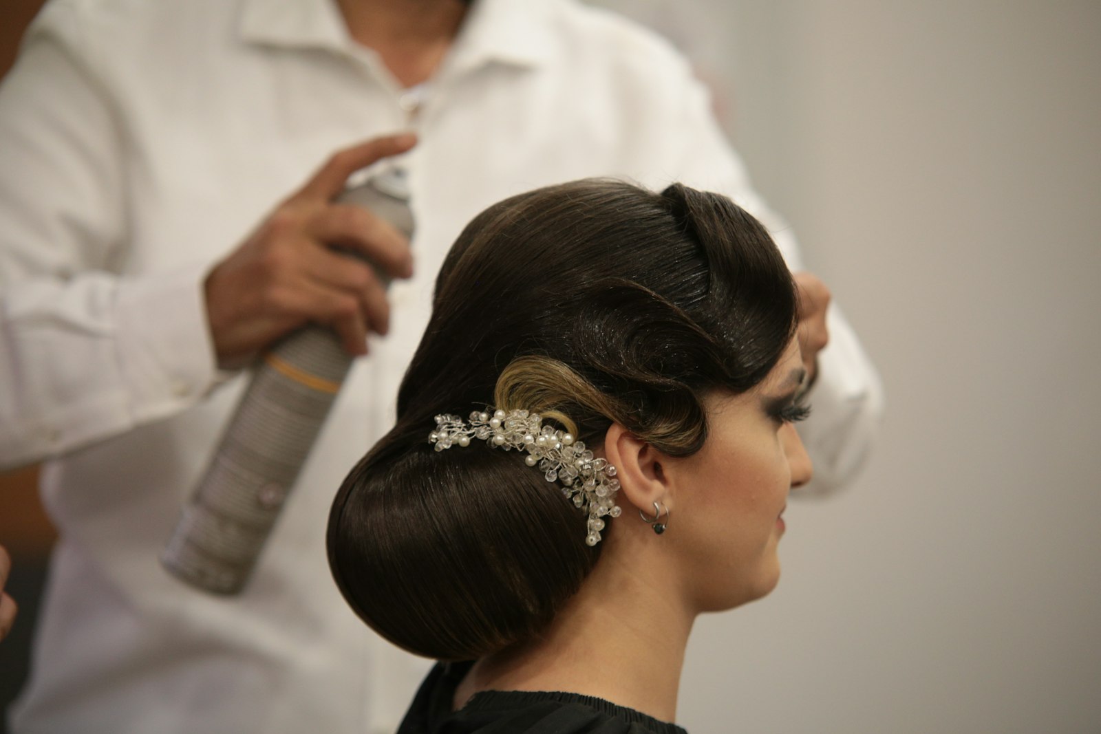 Hochsteckfrisuren Hochzeit: Stylistin frisiert einer Frau die Haare für den großen Tag