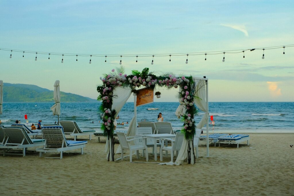 Hochzeit am Meer mit Traubogen auf einem Sandstrand vor dem offenen Wasser