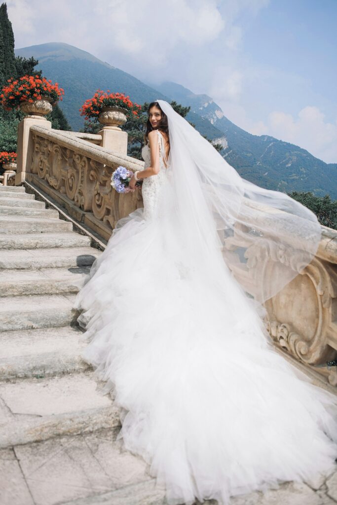 Hochzeit Mallorca: Braut mit Brautstrauß auf einer weißen Treppe
