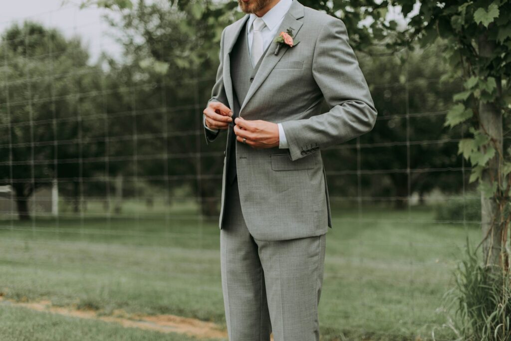 Hochzeitsanzug Trends: Mann schließt den Knopf seines Sakkos mit Kerbrevers