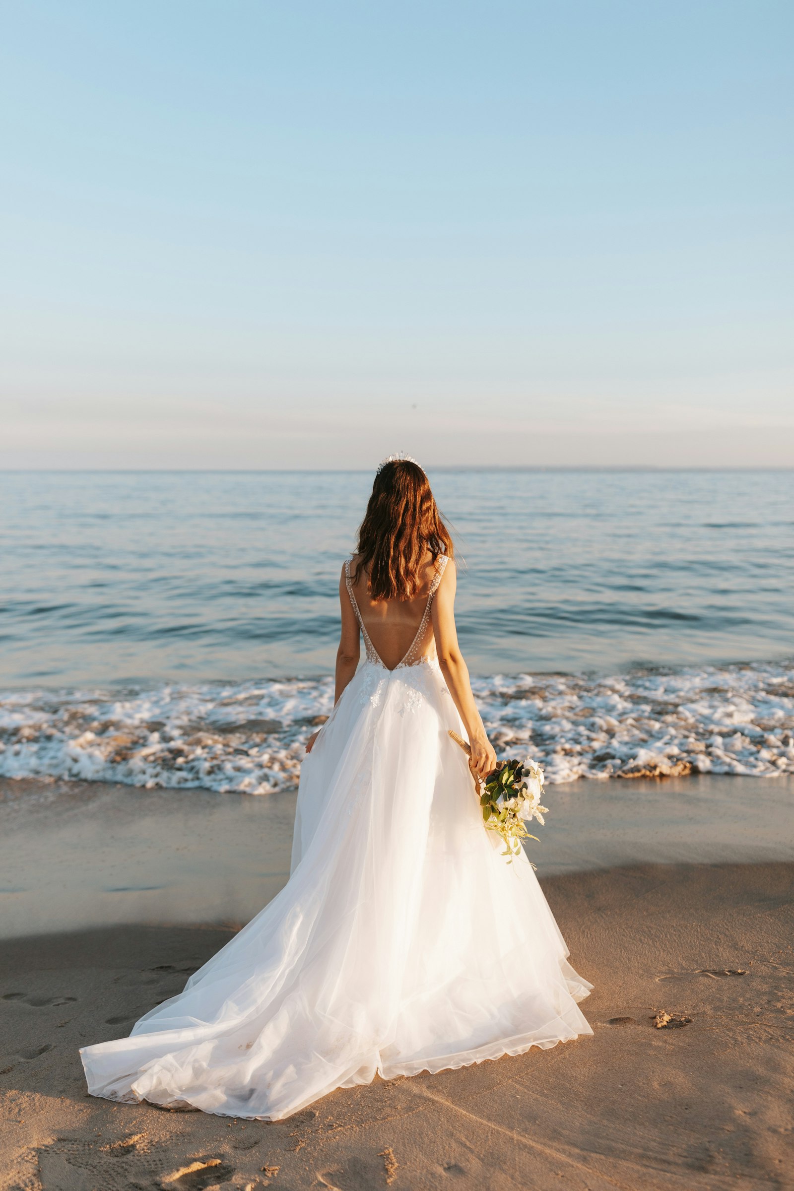 Braut im weißen Kleid am Strand