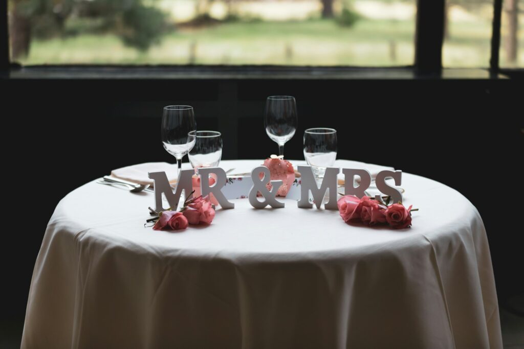 Mr & Mrs Schriftzug auf einem Tisch neben vier Weingläsern
