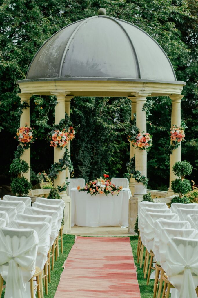 Pavillon unter grünen Bäumen als Trauort für eine Gartenhochzeit